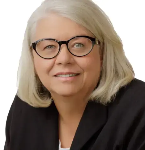 Das Bild zeigt Frau Ingrid Claas mit leicht grauen Haaren, modischer schwarzer Brille und dunkler Kleidung. sie schaut direkt nach vorne, dem Betrachter zugewandt